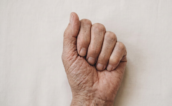 Elderly senior man clenched fist close up hand gesture senior human skin aging detail