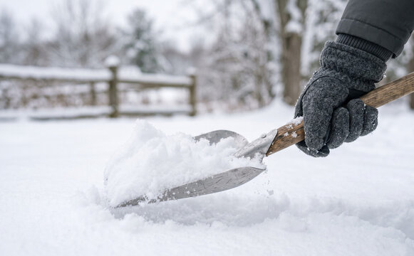 Person shoveling snow in winter outdoors close up, concept of seasonal yard work, maintenance and clearing