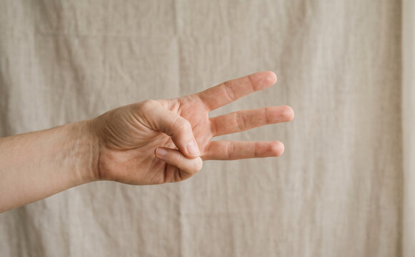 Adult Caucasian man showing three fingers gesturing counting in studio close up