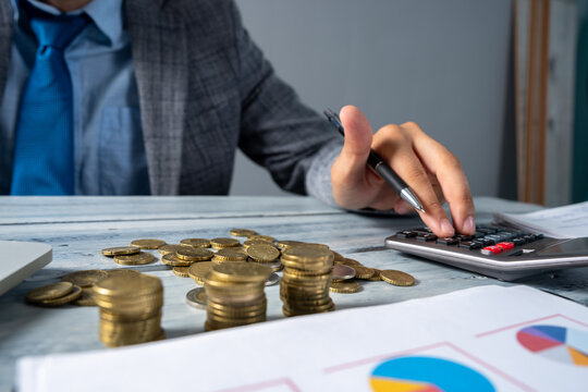 A businessman working at a desk doing financial calculations and analysis