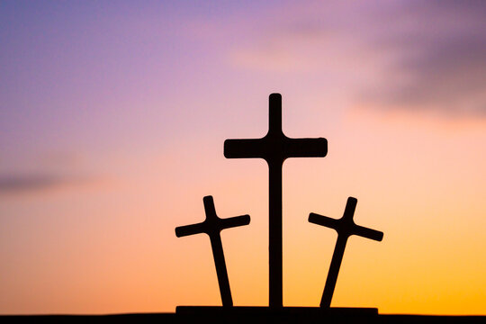 Three crosses at sunset symbolize faith, hope and perseverance.