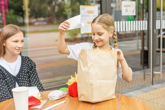 Sisters enjoying fast food together at outdoor cafe