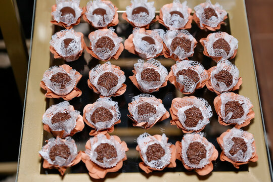 Tray with delicious traditional brigadeiros topped with chocolate sprinkles in flower cups