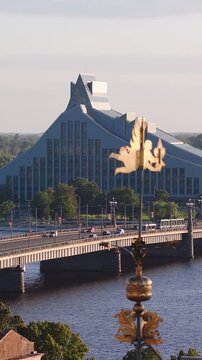 An elevated view across the Daugava river towards Akmens Bridge and the National Library of Latvia in Riga with decorative spire details.