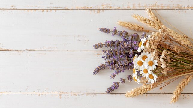 Rustic arrangement of lavender, chamomile and wheat on white wooden background with copy space, harvest season concept