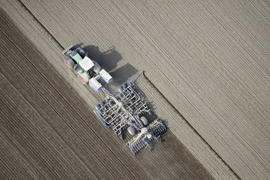 Modern agriculture, tractor working arable land in a field, Schleswig-Holstein, Germany