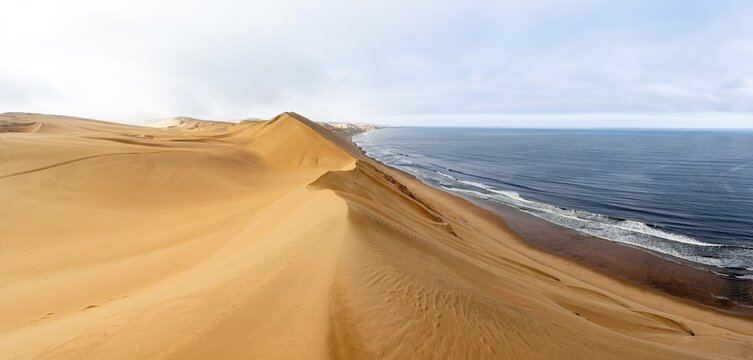 Sand dunes and sea in morning light, Atlantic coast and Namib desert, impressive desert landscape, Sandwich Harbour, Namib Naukluft Park, Namibia