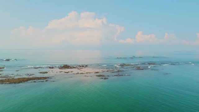 Rocky reef formations appearing above calm ocean waters in Costa Rica sky