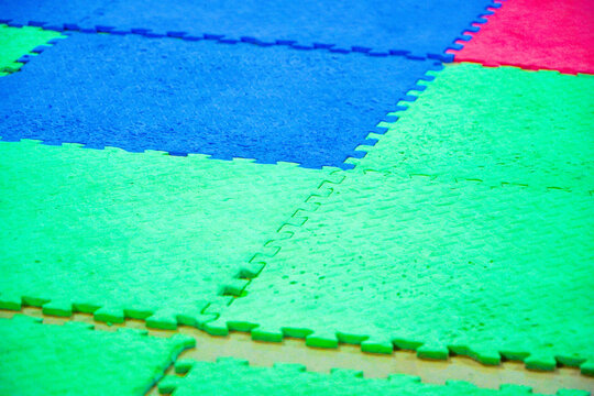 abstract watercolor background. Colorful Interlocked foam Jigsaw tiles on a playmat. disconnected colour puzles. Colorful blue mat texture background. Can be used for yoga, judo or a playground for 