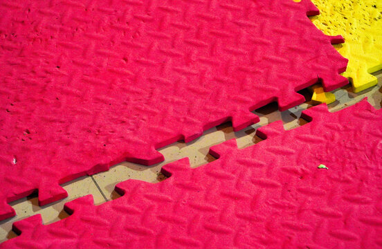 Colorful Interlocked foam Jigsaw tiles on a playmat. disconnected colour puzles. Colorful blue mat texture background. Can be used for yoga, judo or a playground for kids. Busines team work concept. 