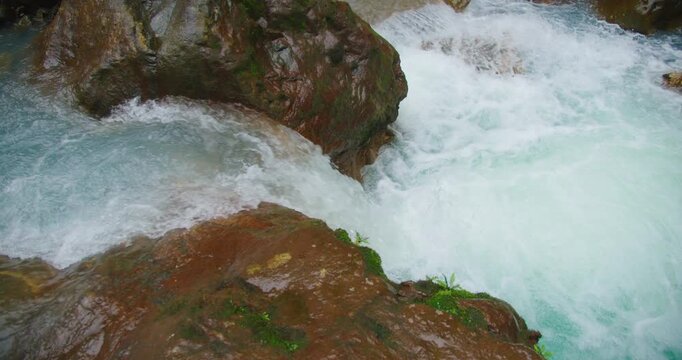Rushing blue river water cascading over rocks in vibrant tropical rainforest of Costa Rica