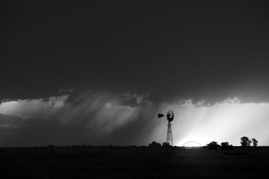 Windmill at sunset with a rain storm in the background, Pampas, Patagonia,Argentina.