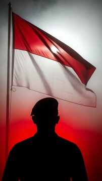Silhouette of a male soldier saluting the Indonesian red and white flag symbolizing national pride, patriotism, and military loyalty