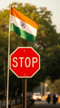 Indian flag waving above a red stop sign on a city street, representing national regulations and traffic safety concepts