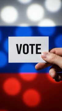 Hand holding vote sign in front of Russian flag representing election democracy and political choice