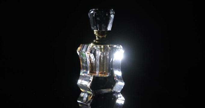 Aromatic perfume in bottle on black background, closeup