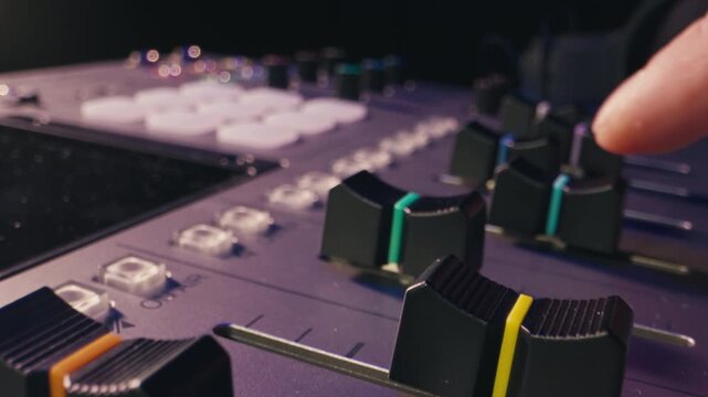 Music studio close up, Close up hands shot of sound engineer using mixing console, remote control for adjusting sound, audio mixer. Musician creates music, makes remix for DJ set. Sound