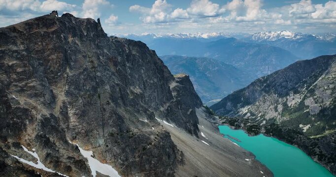 Aerial drone footage of Wedgemount Lake in British Columbia, Canada, showcasing the turquoise alpine lake surrounded by rugged mountains, rocky terrain, and pristine wilderness. Cinematic scenic lands