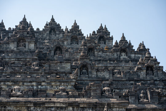 Borobudur temple stone carvings and stupas under blue sky