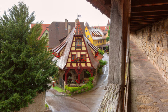 Traditional half-timbered Old Forge building beside the historic town wall in Rothenburg ob der Tauber, Germany.