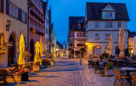 Half-timbered houses and cobblestone streets illuminated by warm streetlights during blue hour in Rothenburg ob der Tauber, Germany.