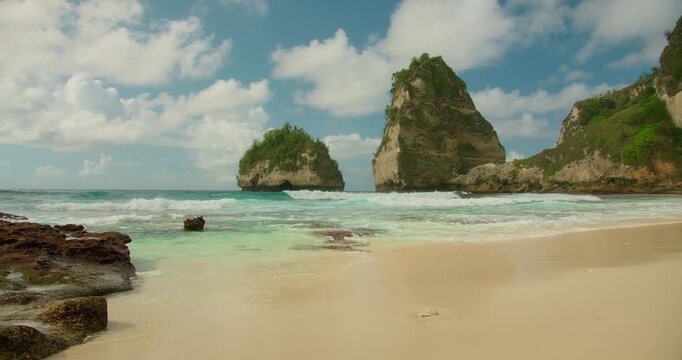 Soft turquoise waves reach the sandy shore of a tropical Diamond Beach in Nusa Penida