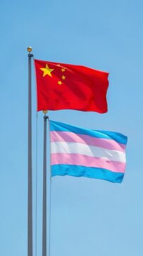 Chinese and transgender flags flying together on flagpoles against a clear blue sky representing unity and diversity