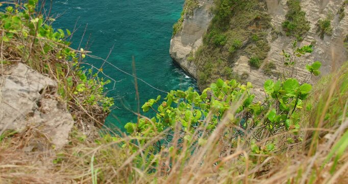 Top of high limestone cliffs overlooking deep blue sea in Nusa Penida Bali Island Indonesia