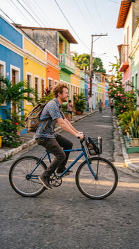 Man cycles past colorful buildings