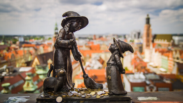 WROCLAW, POLAND-AUGUST 15 2025 Bronze dwarfs Tekla and Martynka on the Witches Bridge with aerial panoramic view of Wroclaw old town in the background