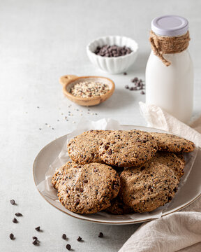 A plate of homemade quinoa cookies with a bottle of milk.