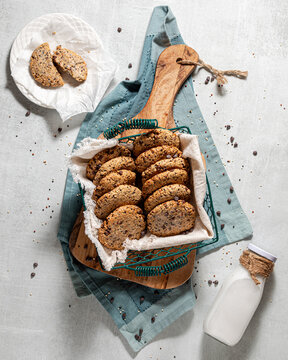 A basket of homemade quinoa cookies with one broken on a plate above.
