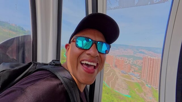 Happy tourist riding metrocable cable car in medellin, colombia