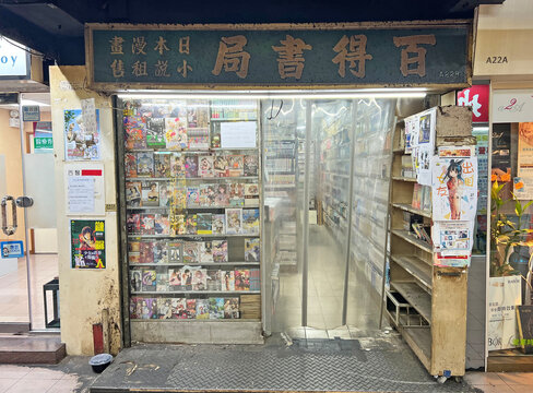 Hong Kong, January 7, 2023: An old comic book rental shop displays Japanese manga titles behind a plastic curtain storefront.