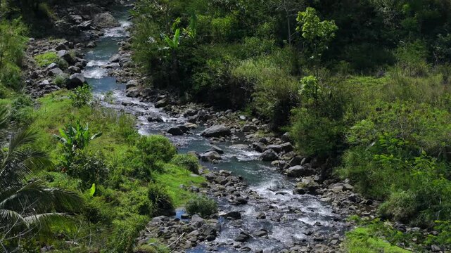 Mountain river flowing through a tropical forest revealing a volcano peak