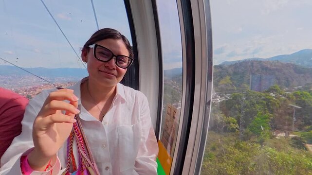 Woman riding cable car above medellin, colombia
