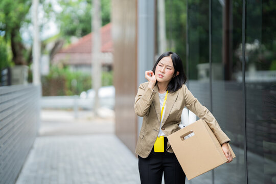 A businessman who has lost his job walks out of the office carrying a box of his belongings, feeling sad and frustrated. He faces a career crisis, stress, uncertainty, and financial difficulties.