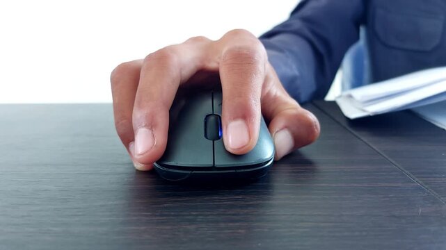 male hand clicking on black computer mouse on work desk. Working with PC or laptop at work