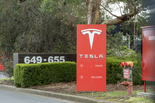 A Tesla branding totem sign directing to Sales and Delivery outside a facility in Mulgrave, Melbourne, Australia.