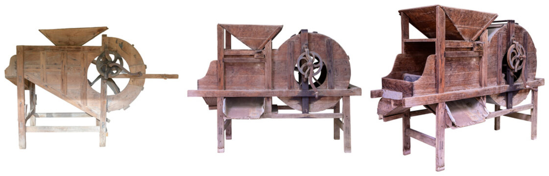 Three antique wooden threshing machines or grain separators isolated on a white background