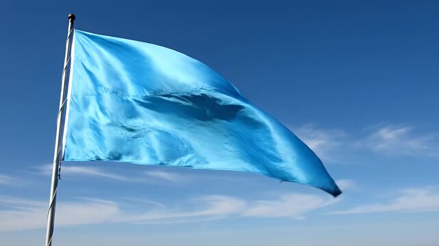 Isolated bright blue flag waving in the wind against a clear blue sky, flapping motion, atmospheric, outdoor
