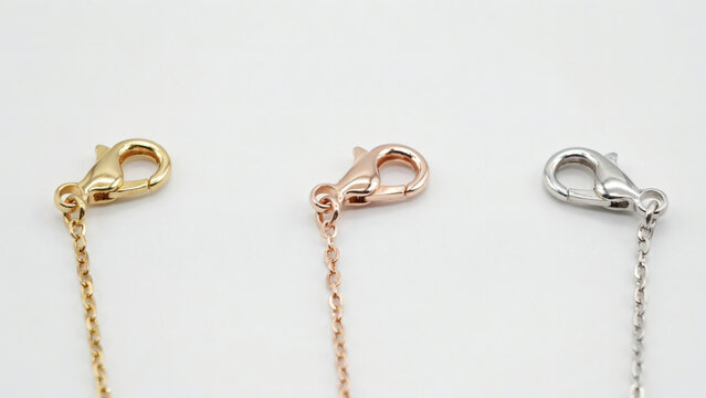 Three elegant metal jewelry chain necklaces featuring gold rose gold and silver lobster clasp closures against a minimalist white background