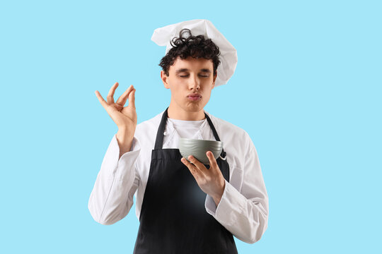 Culinary excellence and gourmet cooking, young chef making chef kiss gesture with bowl of food on blue background
