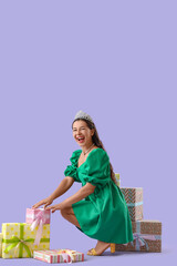 Naklejka premium Birthday celebration and gift giving, happy woman wearing a tiara and green dress surrounded by presents on a purple background