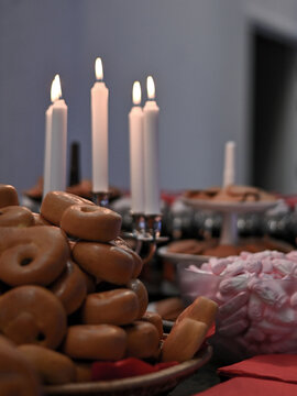Traditional Swedish Lucia fika with lussekatter, pink foam Santa candies and burning candles, creating a warm and festive Scandinavian December atmosphere.