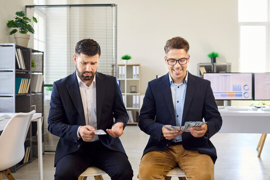 Employees workers salary wages office compensation disparity. Two men count cash, one with a thin bundle and the other a thicker stack, showing payroll inequality. Unfairness in pay gap clear.