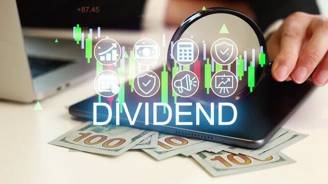 People look at a tablet showing dividend data while some banknotes lie on the table. A laptop is also visible along with financial charts. This scene takes place in an office setting.