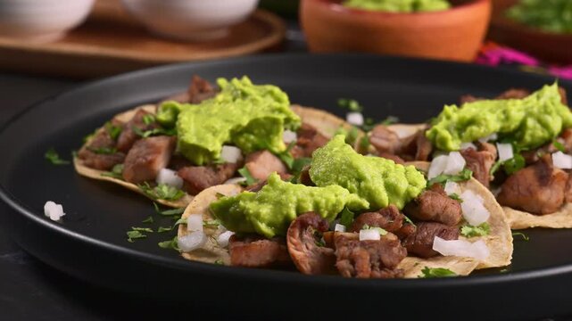 Grilled beef carne asada tacos topped with fresh guacamole and cilantro