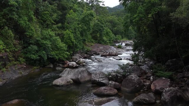 Low Aerial Drone Flight Along a Wild Mountain Stream in Chu Yang Sin National Park, Dak Lak, Vietnam, Showing Rocky Cascades and Multiple Small White Waterfalls Deep in the Forest