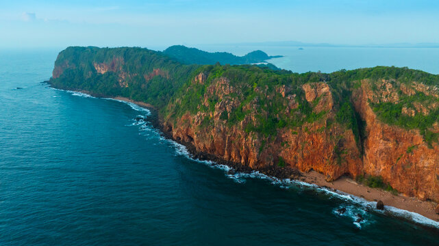 Aerial view of a dramatic, rugged rocky cliff coastline meeting the deep blue ocean water, representing natural beauty, adventure, and travel destinations.concept nature